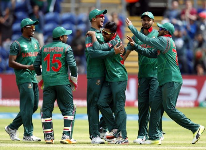 Mosaddek Hossain, centre, celebrates with his Bangladesh teammates after taking the wicket of Corey Anderson