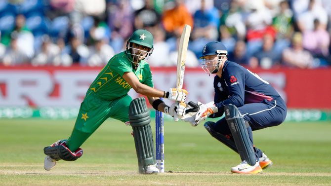 Pakistan's Babar Alzam plays a pull shot as he is watched by England 'keeper Jos Buttler