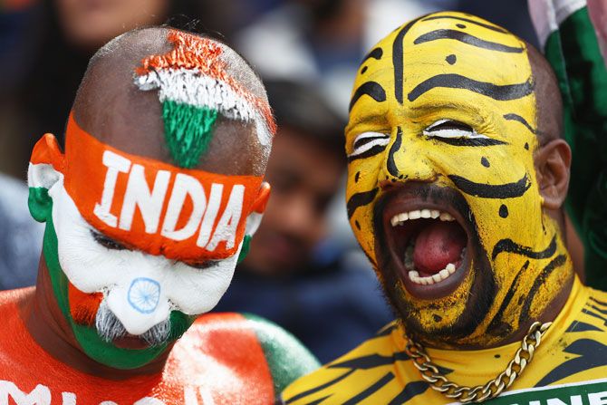 An Indian fan and his Bangladeshi counterpart enjoy a light moment as they watch the proceedings together