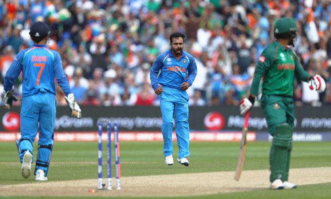 Tamim Iqbal walks off as he is bowled off the bowling of Kedar Jadhav (centre)