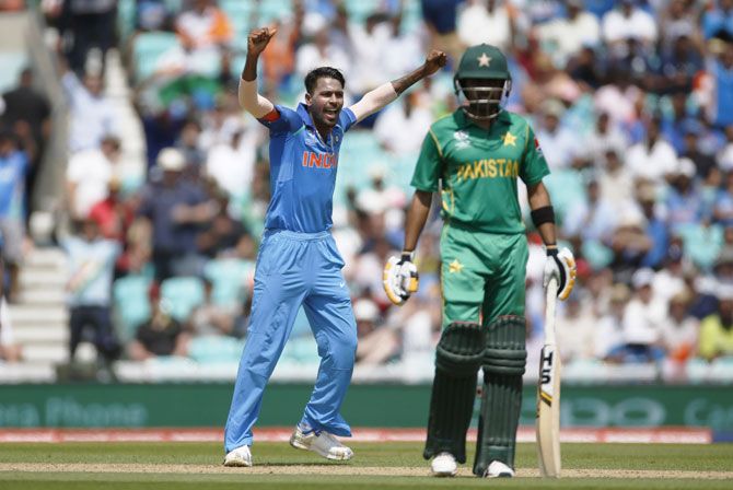 India's Hardik Pandya celebrates taking the wicket of Pakistan's Fakhar Zaman (right)