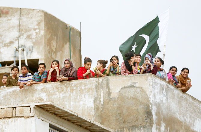 Women and children gather on a roof as they watch Sarfraz Ahmed's homecoming in Karachi on Tuesday