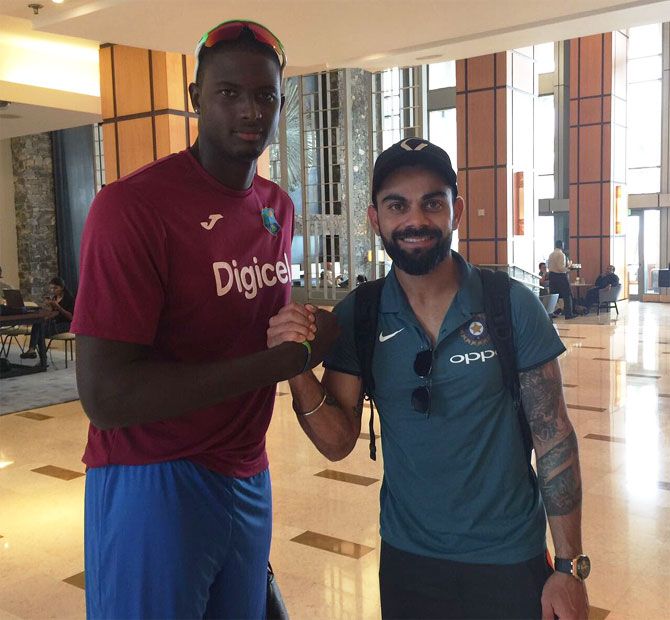 West Indies captain Jason Holder greets Virat Kohli at a hotel on the Indian team's arrival in Port-of-Spain on Wednesday