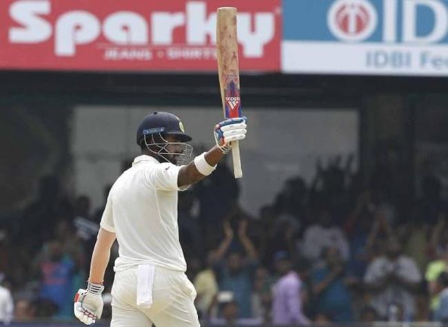 KL Rahul of India raises his bat after scoring 50 runs