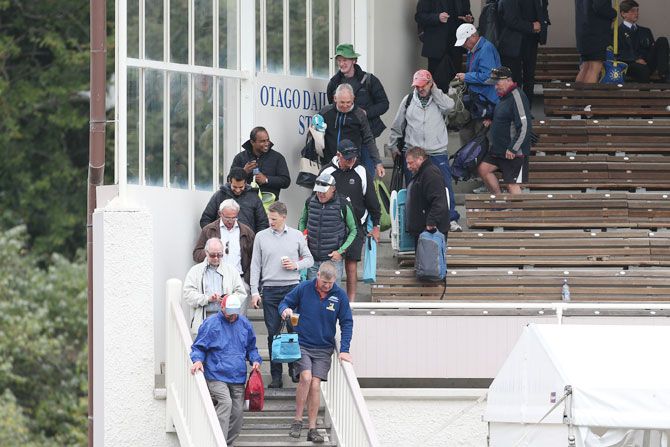 Spectators evacuate the stands after a fire gets set off during day three of the First Test between New Zealand and South Africa at University Oval in Dunedin, New Zealand, on Friday