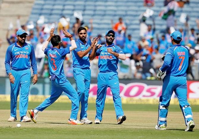 Bhuvneshwar Kumar (centre) celebrates with his teammates