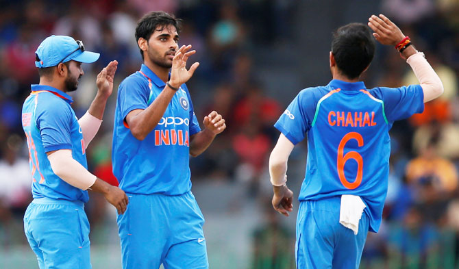 India's Bhuvneshwar Kumar celebrates with his teammates Kedar Jadhav and Yuzvendra Chahal after dismissing Sri Lanka's Niroshan Dickwella