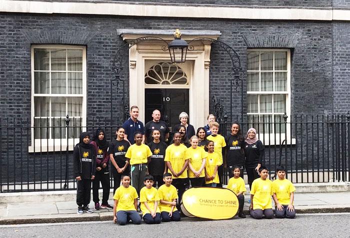 England paceman Stuart Broad and England women's cricketer Heather Knight pose alongside UK Prime Minister Teresa May and children from the charity Chance to Shine