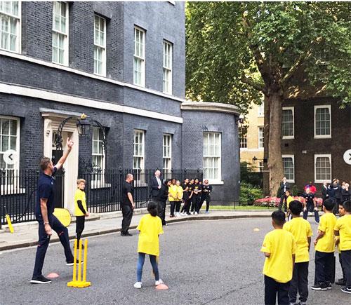 Stuart Broad bowls at one of the participants during street cricket match on Tuesday