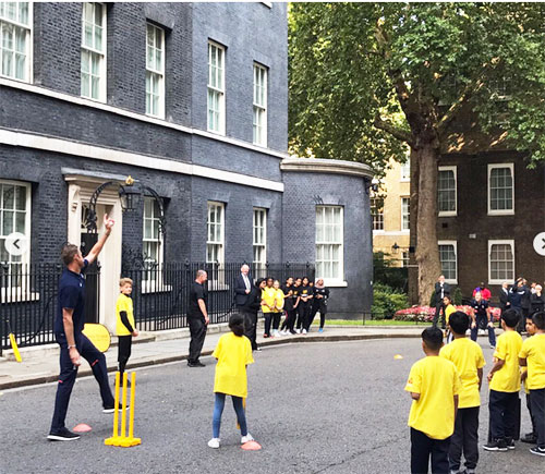 Stuart Broad bowls at one of the participants during street cricket match on Tuesday