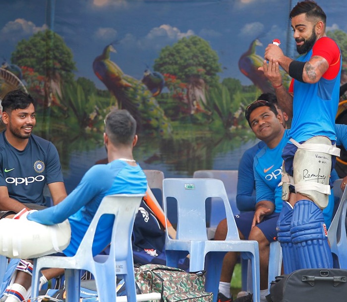 Virat Kohli and his teammates share a light moment as they wait indoors at the Eden Gardens for the weather to improve