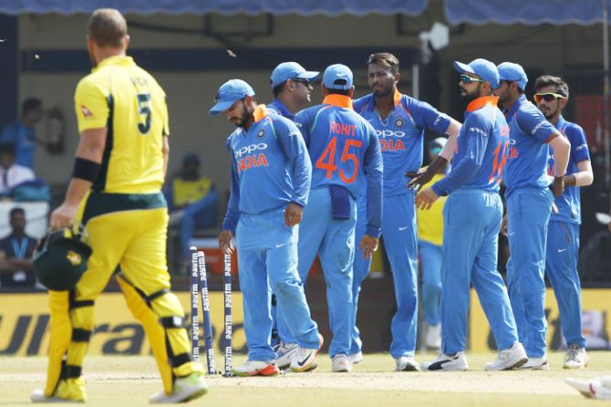 Indian players celebrate the wicket of David Warner