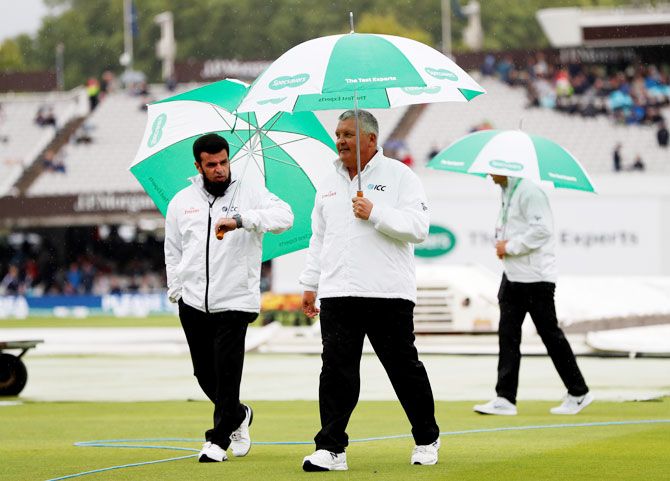 Umpires on their way to inspect the pitch at Lord's during a rain delay on Thursday