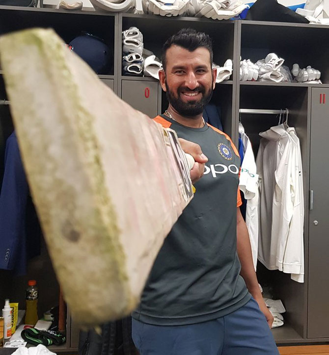 Cheteshwar Pujara celebrates reaching the milestone in the dressing room at the end of day's play on Thursday