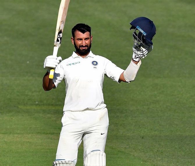 Cheteshwar Pujara celebrates after completing his century on Thursday