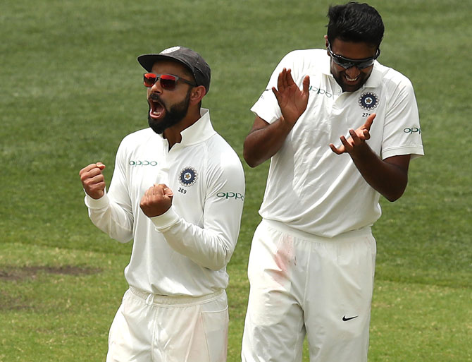 Ravichandran Ashwin, right, celebrates with captain Virat Kohli after taking the wicket of Usman Khawaja