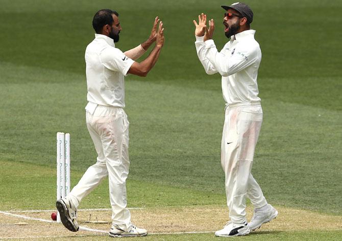 Mohammed Shami, left, celebrates with Captain Virat Kohli after dismissing Pat Cummins. Photograph: Quinn Rooney/Getty Images