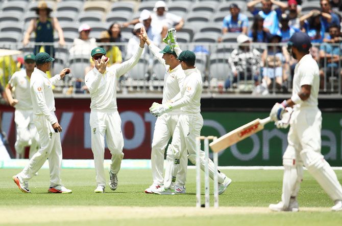 Australia's Peter Handscomb celebrates after taking a catch to dismiss India skipper Virat Kohli off the bowling of Pat Cummins