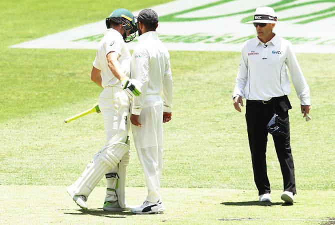 Virat Kohli and Tim Paine nearly brush each other