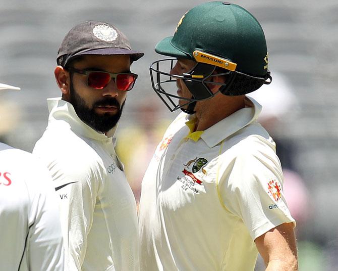  Virat Kohli, left, and Tim Paine bump into each other during a Test match during the 2018-19 Australia tour