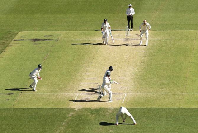 India's Virat Kohli watches the ball as he is caught in the slips by Usman Khawaja off the bowling of Nathan Lyon