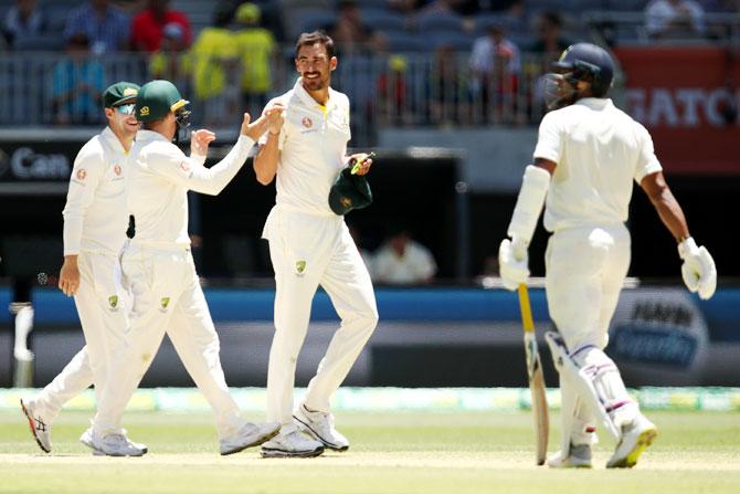 Mitchell Starc celebrates after dismissing Umesh Yadav