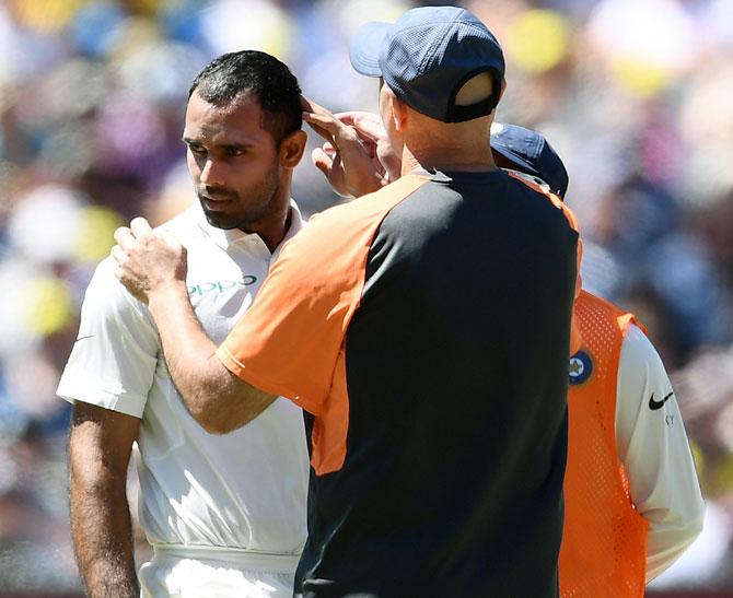 Physio Patrick Farhat checks on Hanuma Vihari after he was hit on the helmet by a bouncer from Pat Cummins. Photograph: Michael Dodge/Getty Images