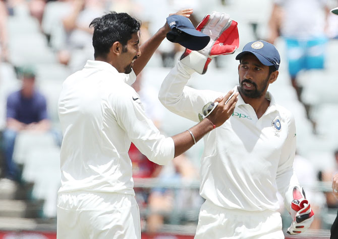 India's Jasprit Bumrah and Wriddhiman Saha celebrate the wicket of South Africa captain Faf du Plessis on Day 4 of the 1st Test at Newlands in Cape Town on Monday