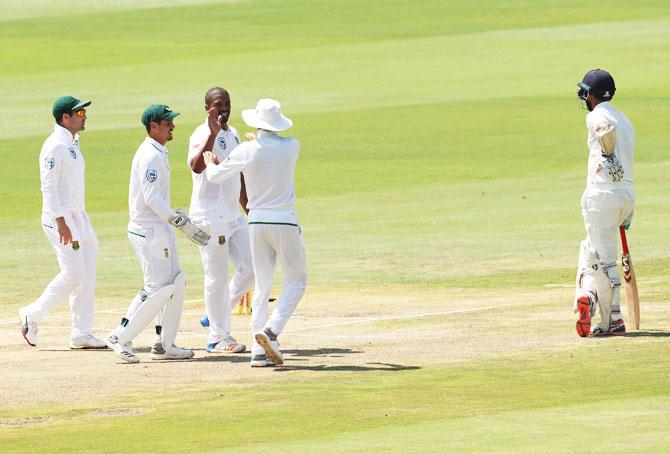 Vernon Philander celebrates with teammates after Cheteshwar Pujara (right) is run