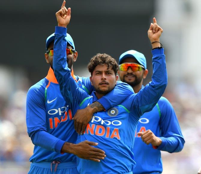 Kuldeep Yadav is congratulated by skipper Virat Kohli and Suresh Raina after dismissing England’s Joe Root