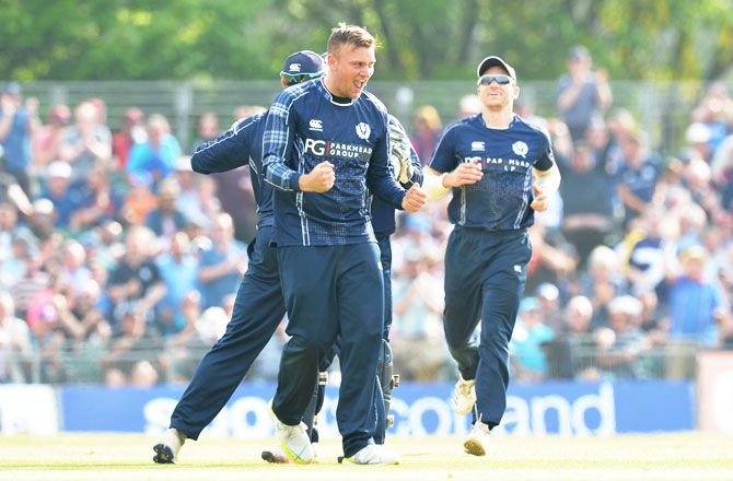 Scotland's Mark Watt celebrates with his teammates after taking the wicket of England's Sam Billings