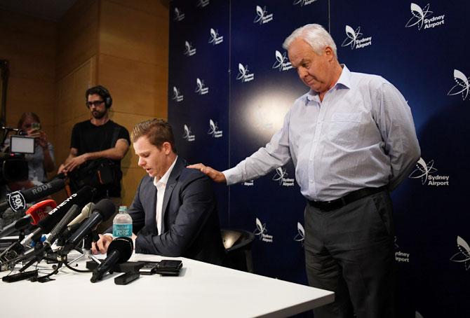 Steve Smith is comforted his father Peter during the press conference