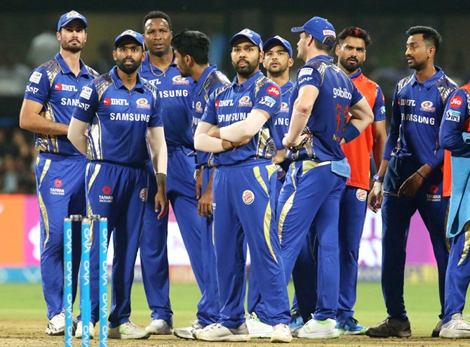 Mumbai Indians players await a review decision