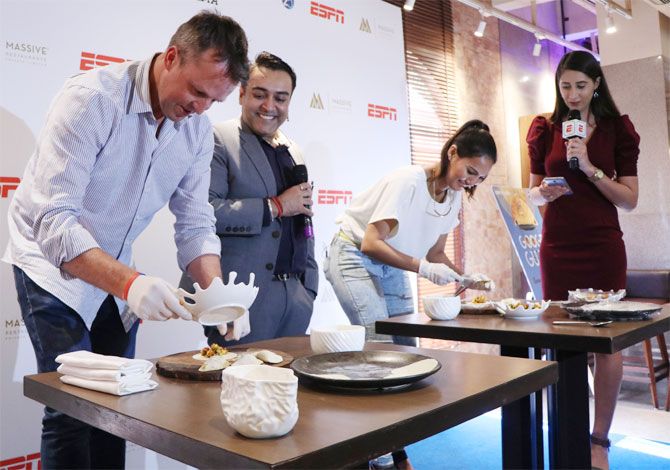 Former England off-spinner Greame Swann and television presenter Rochelle Rao prepare 'Google Gujiya' as Massive Restaurants' Zorawar Kalra (centre) eggs them on
