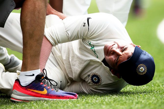 Prithvi Shaw grimaces in pain as he injures his ankle following an attempted catch on the boundary
