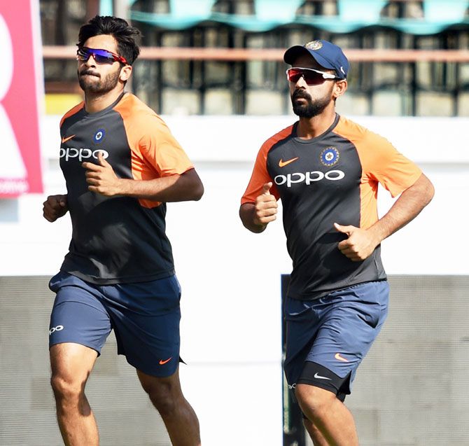 Pacer Shardul Thakur and vice-captain Ajinkya Rahane warm-up at a training session in Rajkot on Wednesday