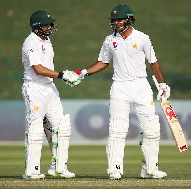 Pakistan's Fakhar Zaman celebrates with Azar Ali after reaching his half century on Day 2 of the 2nd Test against Australia at Sheikh Zayed stadium in Abu Dhabi, United Arab Emirates, on Wednesday