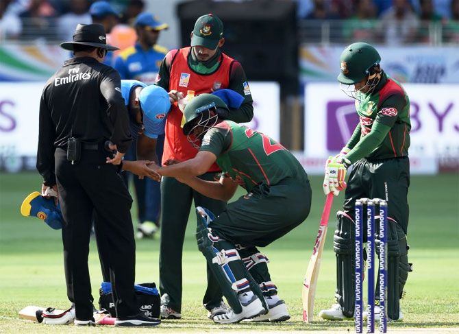 Bangladesh's Tamim Iqbal is checked on by medical staff after getting hit on the hand during the Asia Cup opener against Sri Lanka on Saturday