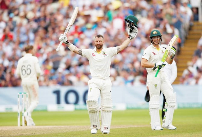 Matthew Wade celebrates his century as skipper Tim Paine applauds