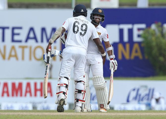 Sri Lankan batsman Kusal Mendis (right) is congratulated by Angelo Mathews after reaching his 50