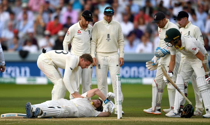 Australia's Steve Smith is checked on by Australian bowlers after he was hit by a Jofra Archer delivery in the 2nd Ashes Test