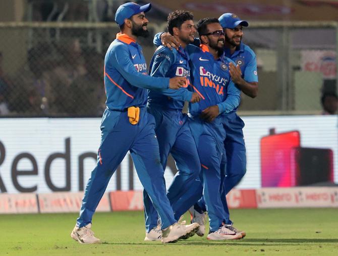 Kuldeep Yadav, 2nd right, celebrates with his team-mates after taking the wicket of Alzarri Joseph to complete his hat-trick