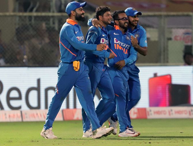 Kuldeep Yadav, 2nd right, celebrates with his team-mates after taking the wicket of Alzarri Joseph to complete his hat-trick