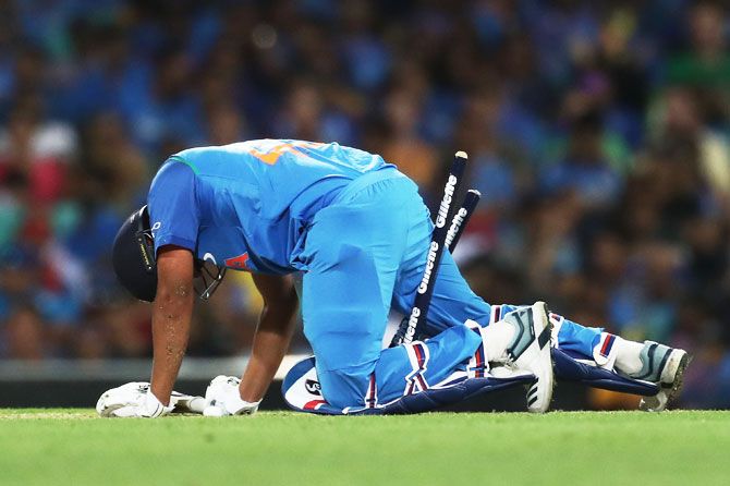 Rohit Sharma crashes into the stumps as he tries to get back into the crease