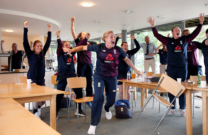 Members of the current ICC Women's World Cup winning England squad (l-r) Lauren Bell, Katie George, Nat Sciver, Katherine Brunt, Tammy Beaumont and Anya Shrubsole are ecstatic as they watch the England men's team win the ICC Cricket World Cup final against New Zealand, during Day Three of the International Friendly match between England Women and Australia A Women at Millfield School in Glastonbury, England, on Sunday