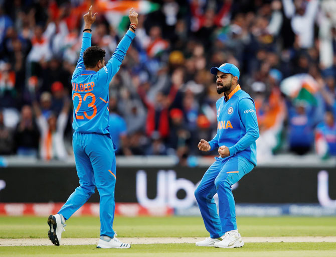 India's Kuldeep Yadav celebrates with captain Virat Kohli after picking the wicket of Pakistan's Babar Azam