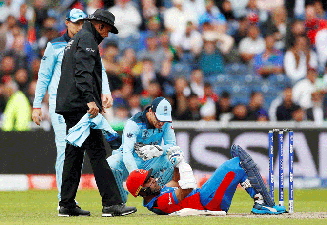 Afghanistan's Hashmatullah Shahidi goes down after being hit on the head off a bowl from England's Mark Wood during their ICC World cup match at Old Trafford in Manchester on Tuesday