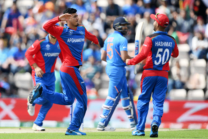 Afghanistan's Mujeeb Ur Rahman (left) celebrates with Hashmatullah Shahidi (right) on taking the wicket of India's Rohit Sharma