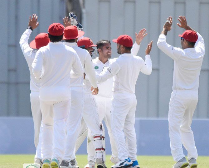 Afghanistan's Rashid Khan celebrates with teammates a the fall of an Ireland wicket in the one-off Test in Dehradun in March.