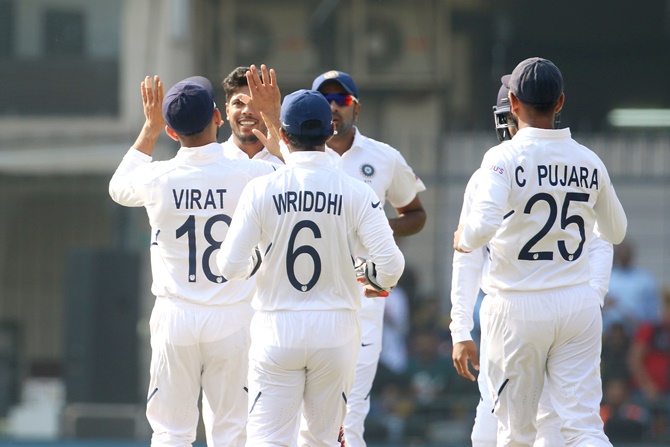 Umesh Yadav is congratulated by captain Virat Kohli and his India after dismissing Bangladesh opener Imrul Kayes